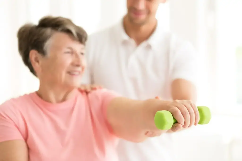 starsza kobieta ćwicząca z fizjoterapeutą